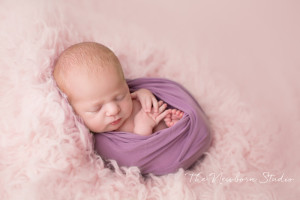 newborn baby girl wrapped purple and pink
