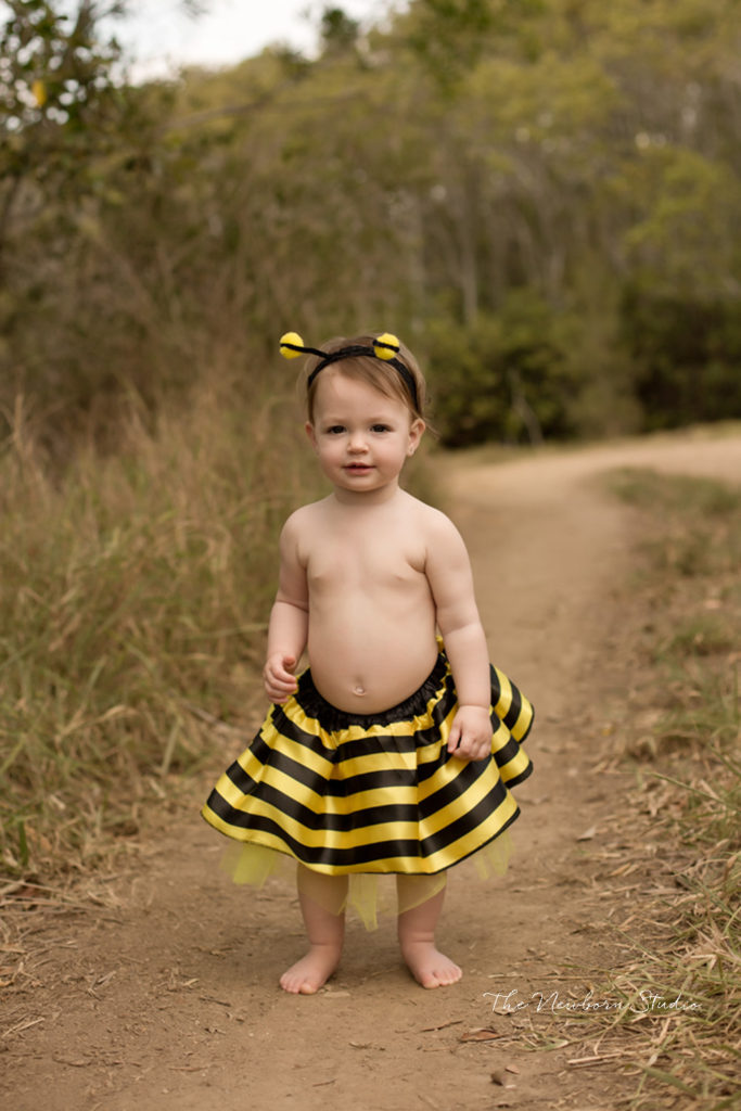 baby girl one year old standing outdoors