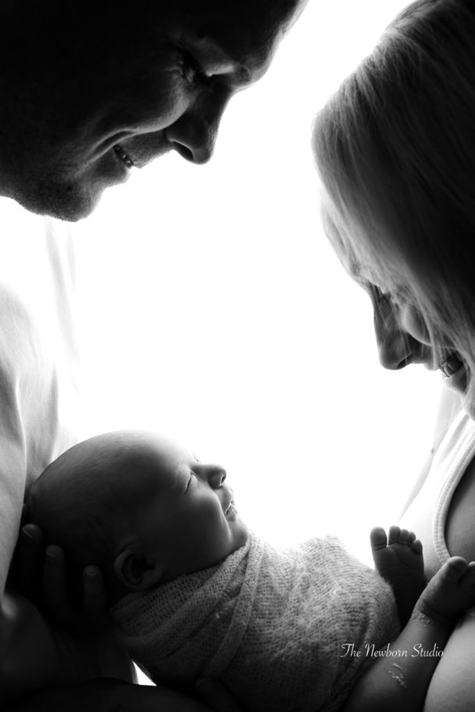 parents family of three baby backlit black and white