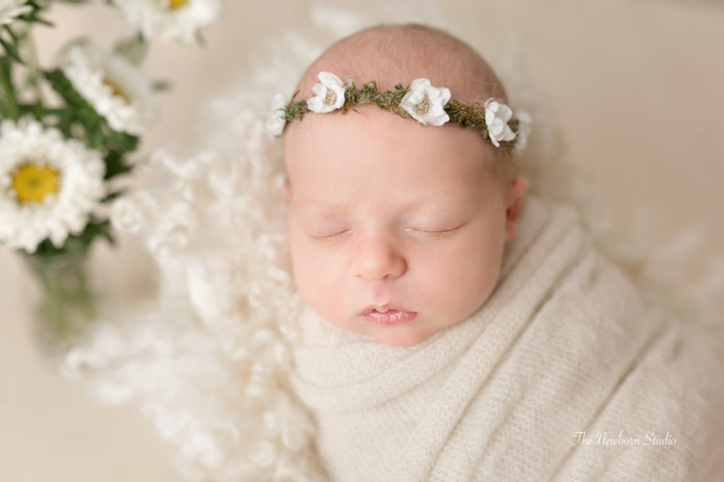 newborn baby girl wrapped flowers floral