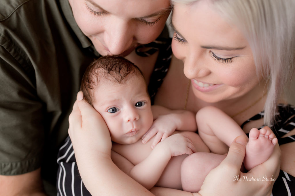 newborn baby boy cuddles parents photo studio