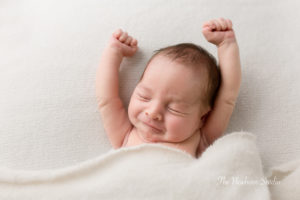 newborn baby boy stretching his arms