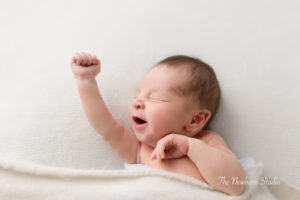 newborn baby boy yawning high 5