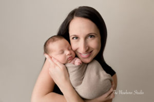mum smiling holding newborn baby boy