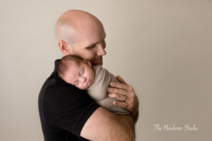 dad cuddling newborn baby