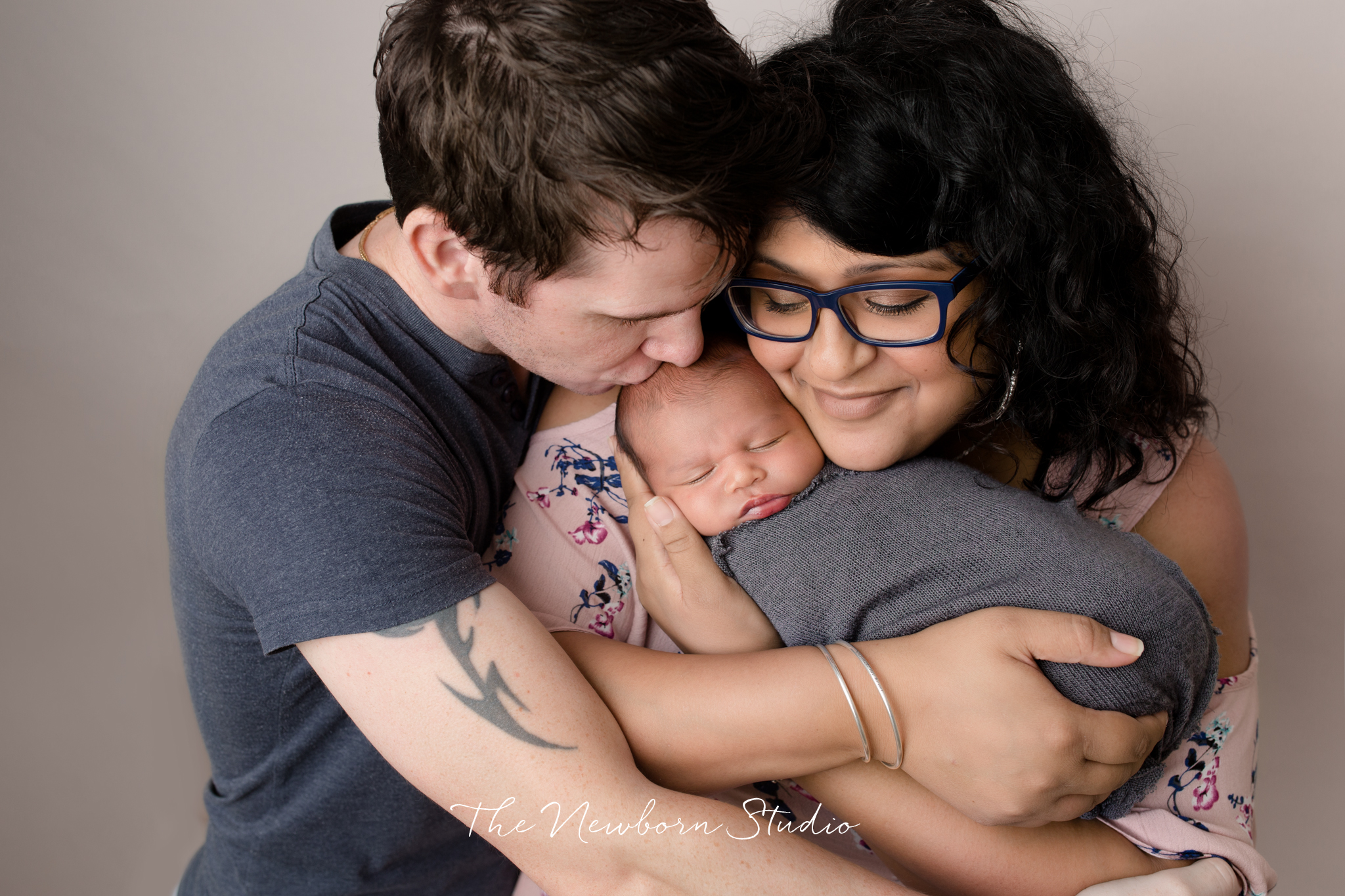 newborn baby boy and parents cuddle 