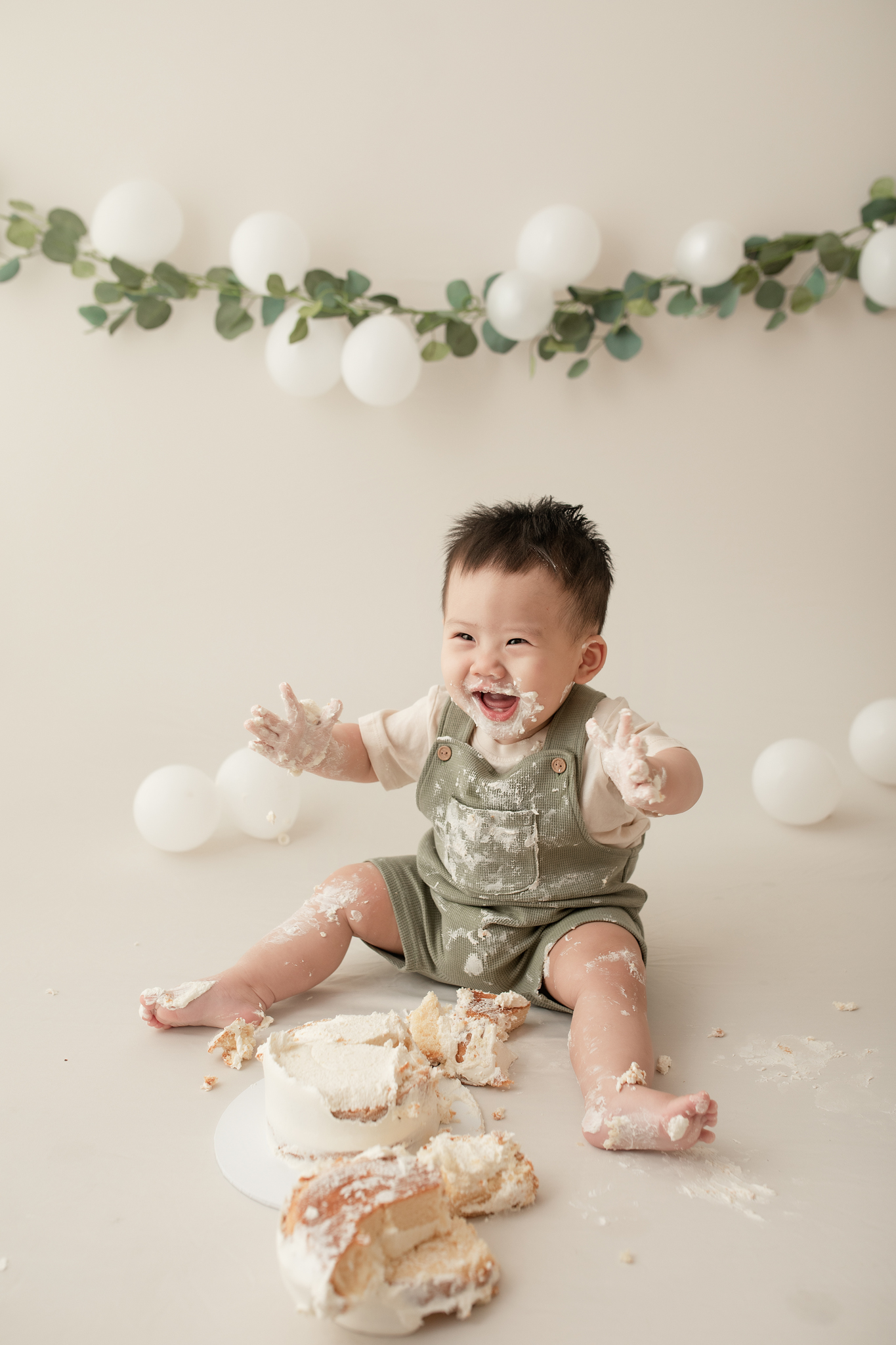 asian baby boy excited smashing a cake in photo studio