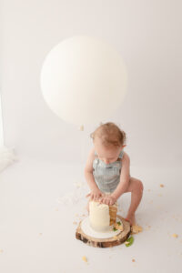 one year old boy smashing cake in photo studio