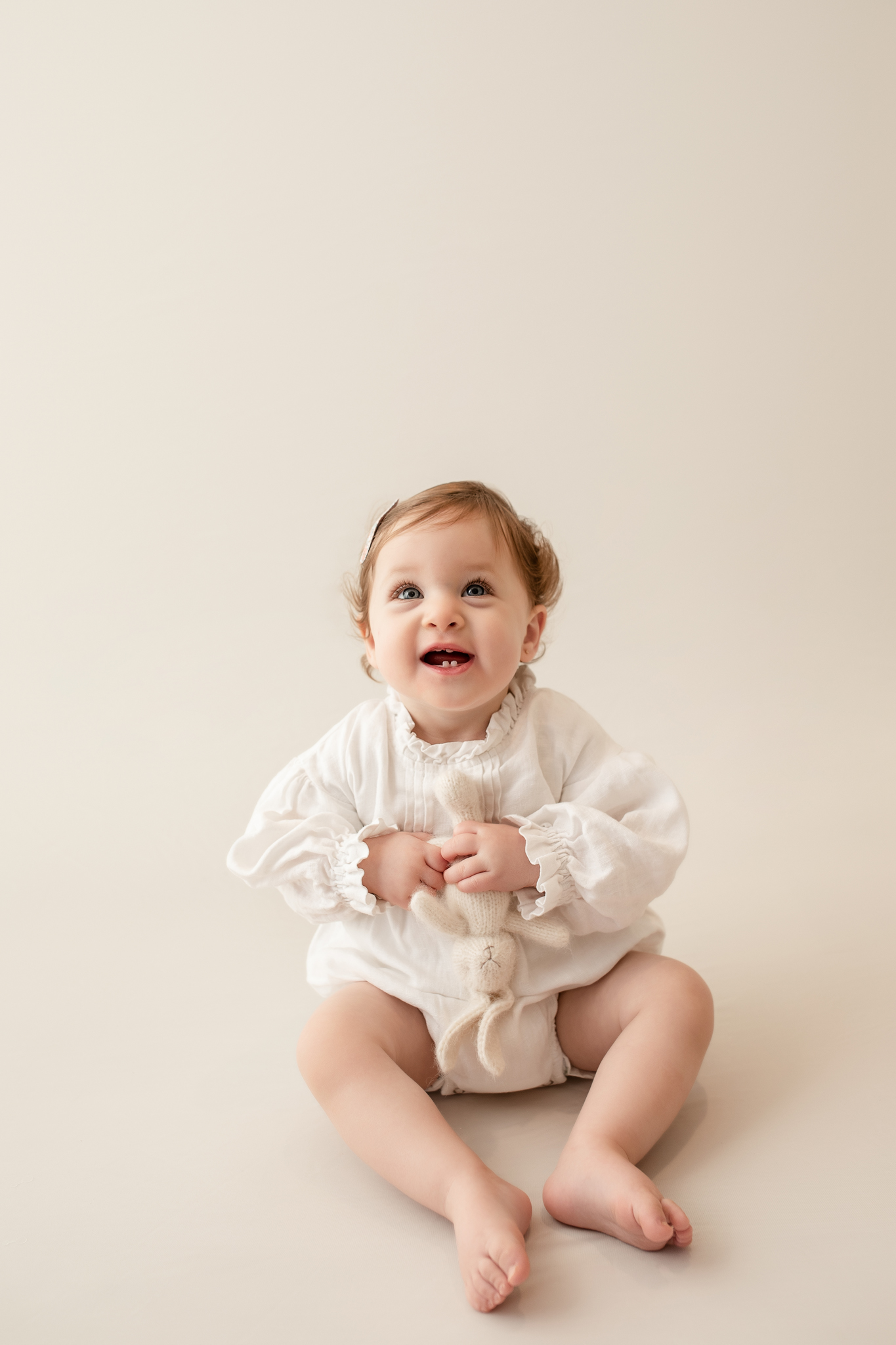 happy one year old girl in photo studio