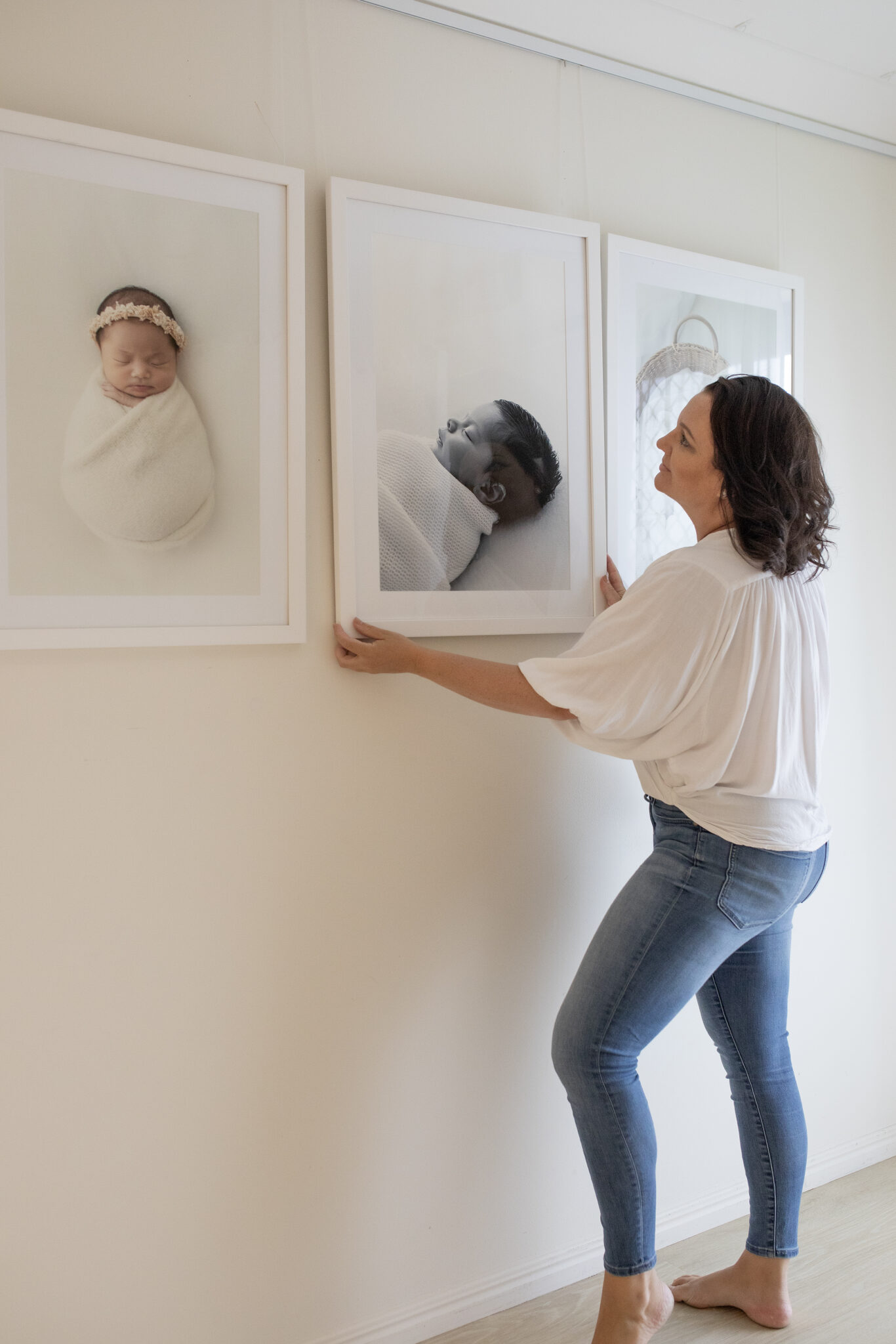 girl hanging photos on wall