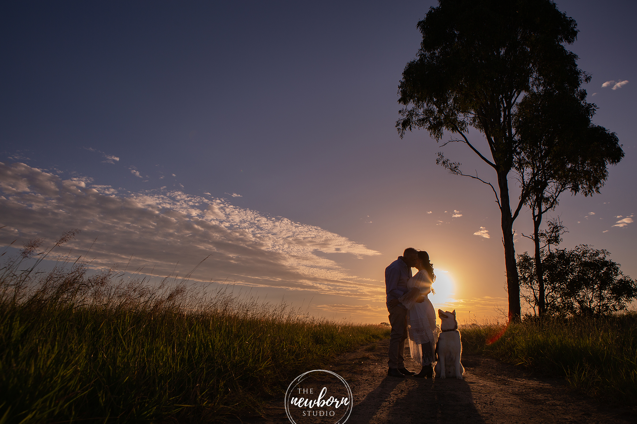 couple together with their dog at sunset