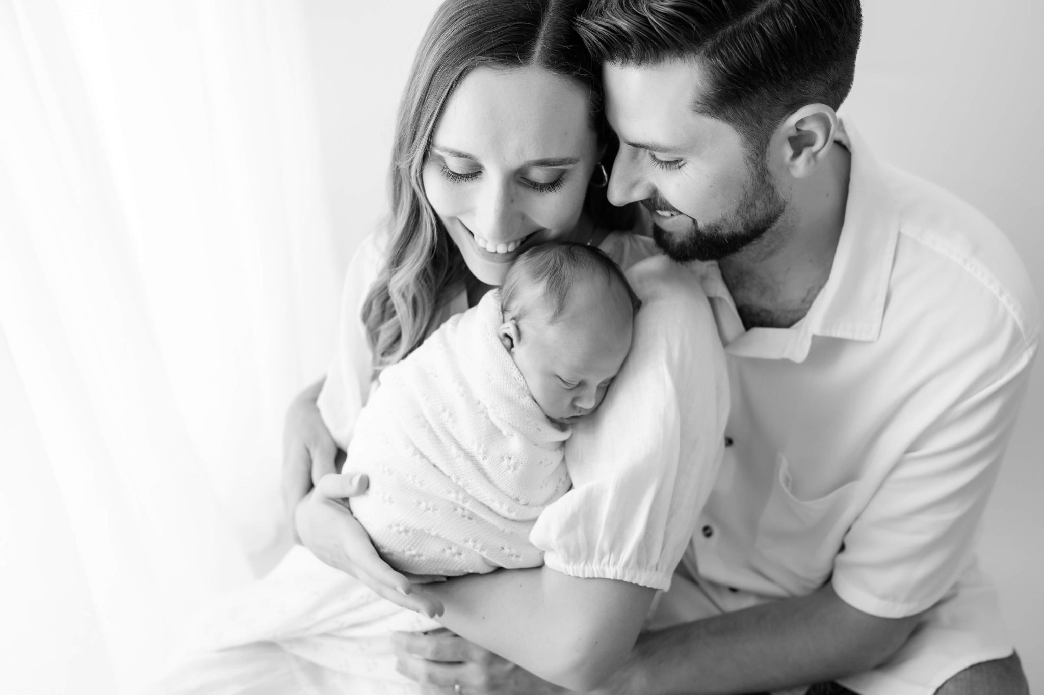 parents hugging newborn