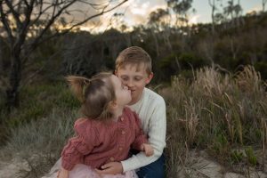 siblings hugging at the beach sand dunes