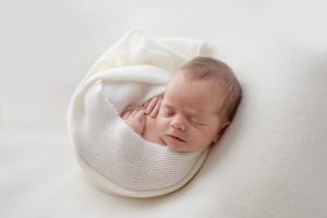 newborn baby girl curled up