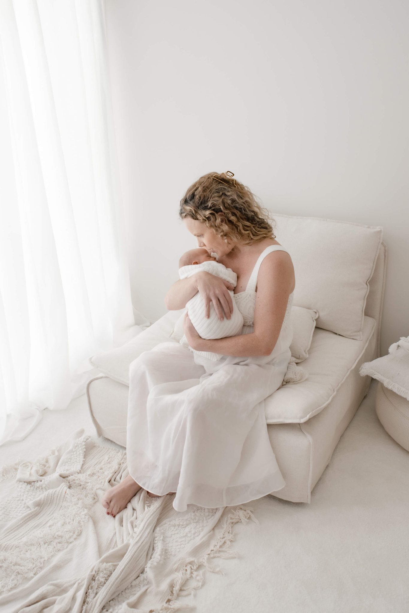 mum holding baby in brisbane newborn photography studio