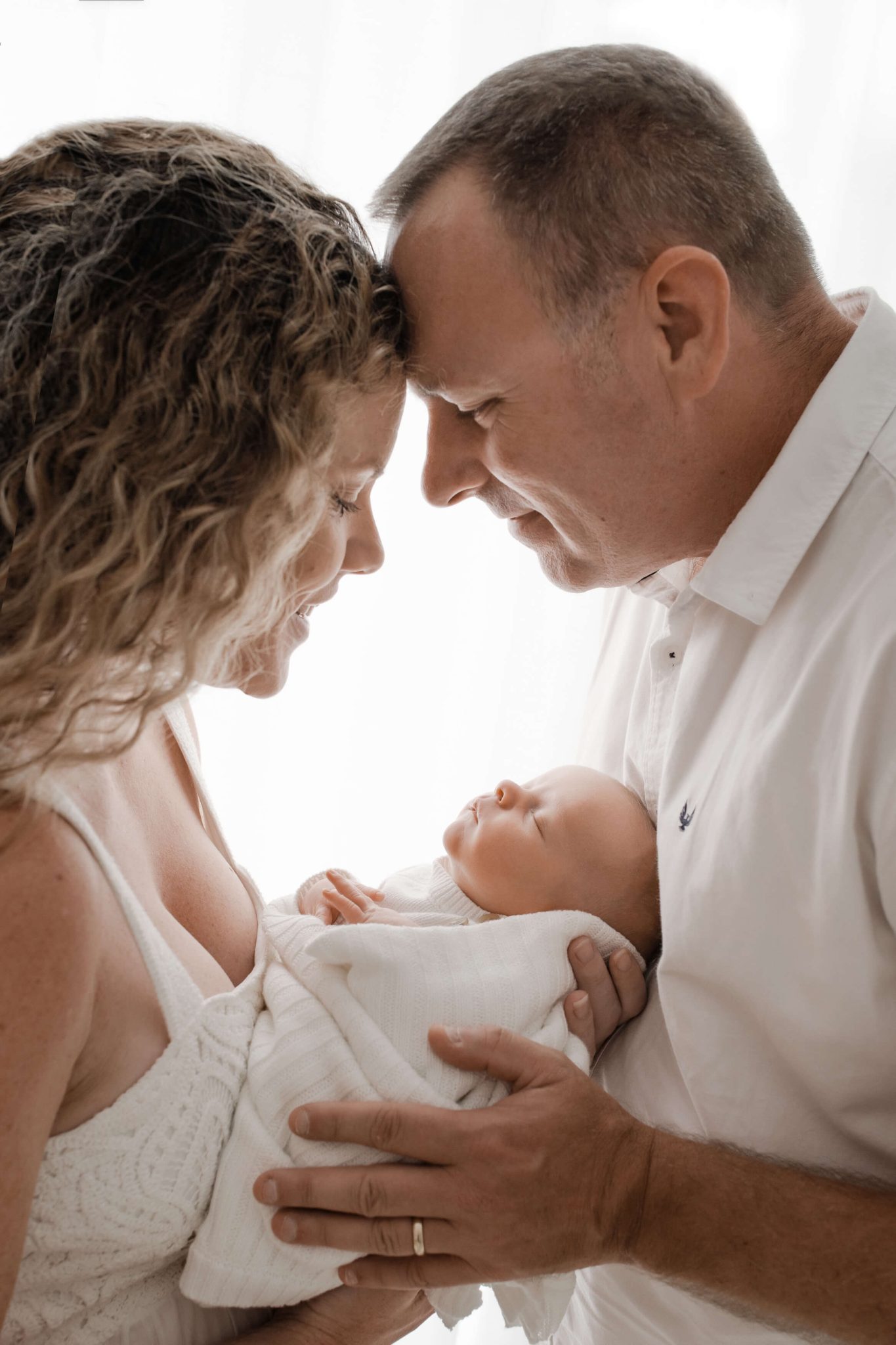 parents holding baby in brisbane newborn photo studio